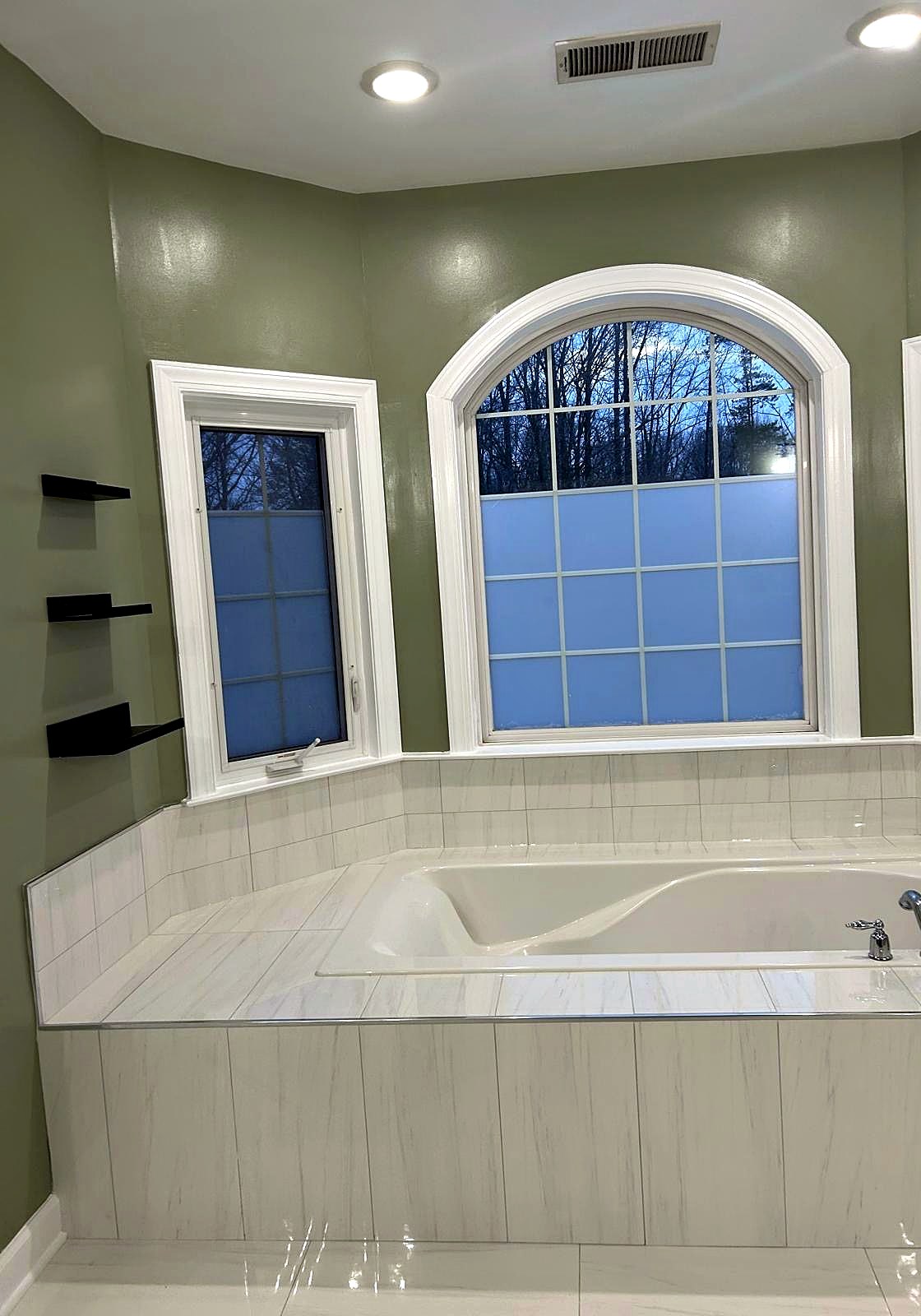 Tiled tub deck under an arched window