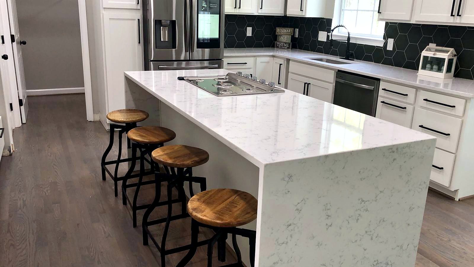 Kitchen with waterfall quartz island and black hex backsplash